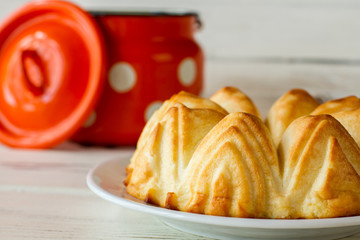 Curd casserole on white plate. Opened milk can and cheesecake. Healthy and nutritious breakfast. Cottage cheese pastry.