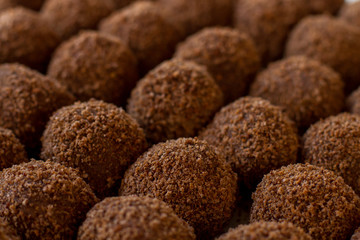 Dark colored sweets. Rows of brown candies. Delicious dessert from russian cuisine. Butter and crumbled cookies.