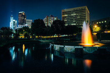 Obraz premium The Uptown skyline and a fountain at Marshall Park at night, in