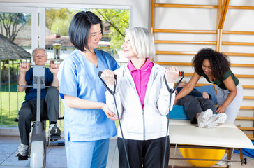 Obraz premium Nurse assisting elder people in a rehab facility gym