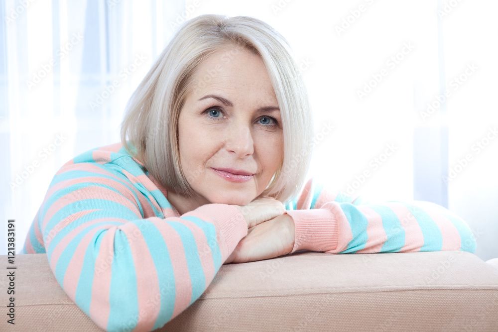 Wall mural Attractive middle aged woman relaxing at home. The beautiful face close up.