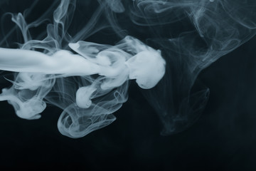 Cloud of smoke on black background. Selective focus. Toned