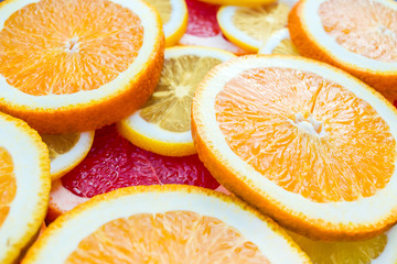 Fototapeta na wymiar Bright and fresh lemon, orange, grapefruit. Colorful citrus fruit slices background. Side view picture