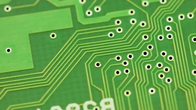 extreme close up shot of a green turning printed circuit board
