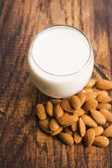 Almond milk with almond on a wooden table