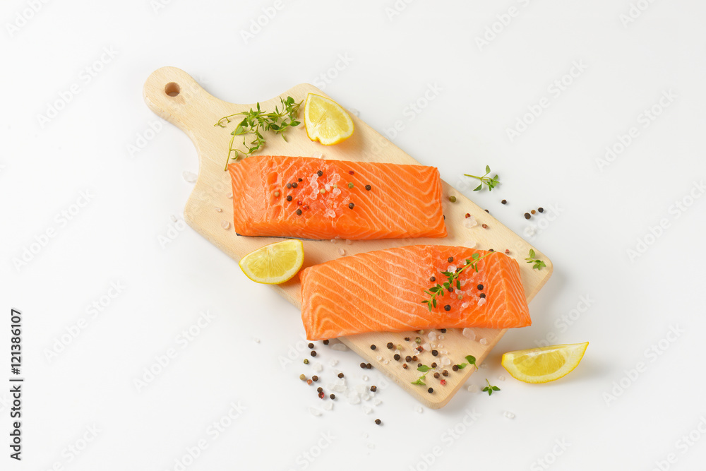 Poster raw salmon fillets on cutting board