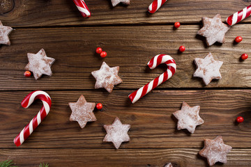 Christmas background. Christmas canes and cookies in the shape of stars on a wooden background