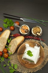 Goat cheese with fresh tomatoes on wooden table. Fresh cheese and pastries. Diet food. Goat cheese with vegetables.
