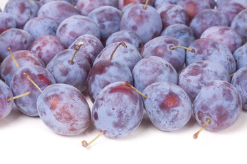 heap of blue plums isolated on a white background