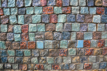 Wall of multi-colored square paving stones for background