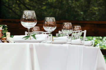 The decor at the wedding. Table for guests on the veranda, in the background of the green Park.