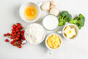 The selection of ingredients for the preparation of traditional French dishes quiche lorraine, on white wooden table, top view, copy space