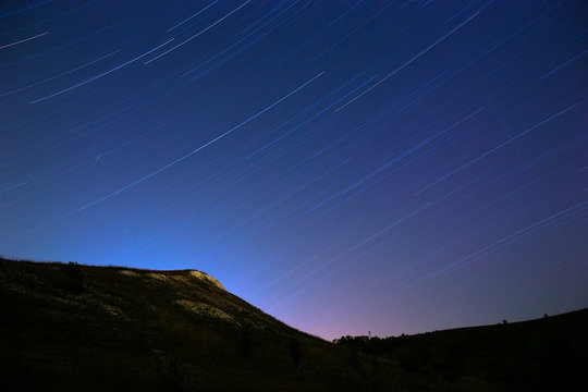 Star trail in the night sky. The slope of the mountain on a back