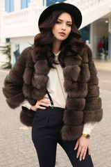 Fototapeta premium woman with dark hair in elegant clothes and luxurious fur coat