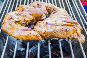 Pork roast with crackling roasting on charcoal grill
