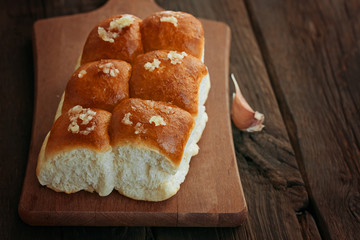 Buns with garlic on a wooden background