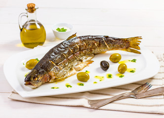 Grilled trout with olive on plate