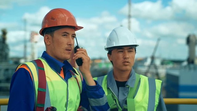 Industrial workers controls work in a factory with walkie-talkie
