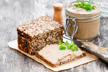 homemadeliver  pate with parsley in a jar on a rustic wooden tab