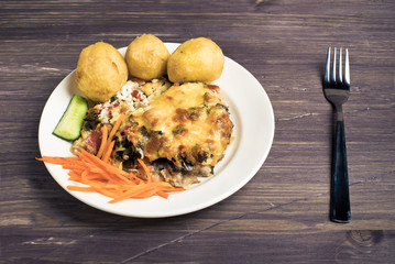 baked meat and potatoes on a wooden background