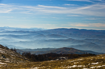 Obraz premium Rolling hills and mountains at autumn sunny day with fog, view from Zeljin mountain, Serbia
