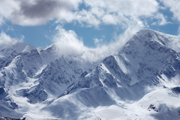 View of the high mountains on the cloudy sky background