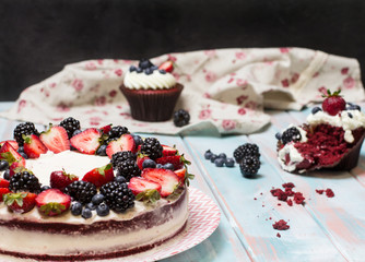 Red velvet cake decorated with berries on a colored background, horizontal, selective focus