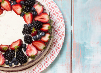 Red velvet cake decorated with berries on a colored background, horizontal, top view