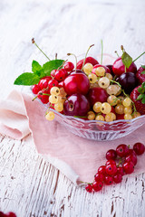 Fresh summer berries and fruits in glass bowl