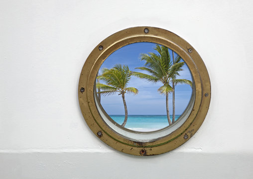 porthole of a ship with view on tropical secene