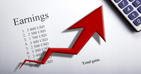 table with earnings with digits, calculator and diagram