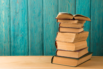 stack of books on the desk over wooden background