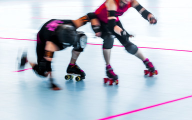 Roller derby skaters action blur. Motion pan shot at rink competition. Collision