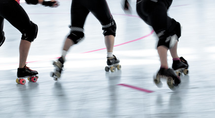 Roller derby skaters action blur. Motion pan shot at rink competition.