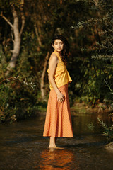 Young Hispanic Girl in Handmade Clothing in River in Nature