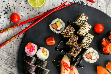 Big sushi set, the hand that holds the chopsticks, the view from the top