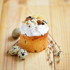 Easter composition with quail eggs nuts dried fruits holiday cake and willow branches on wooden table