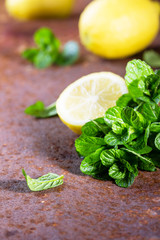 Fresh mint and lemon slices on rustic background