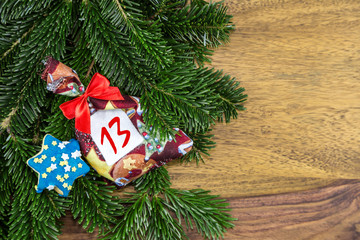 ein Weihnachtssäckchen und ein blauer Stern liegen auf Tannenzweigen