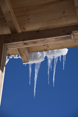 Detail of ice stalactites on a wooden roof