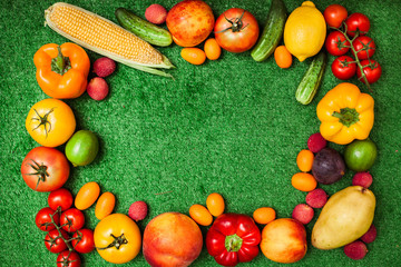 group of fruits and vegetables arranged in a circle on a background of green grass. Free space for text in the middle.Group of fruits and vegetables