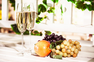 Grapes clusters, ripe apple and two glasses of white wine. Autumnal fruits harvest. Horizontal