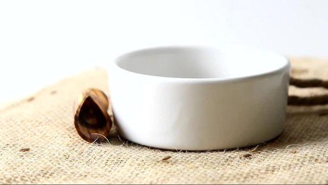 Cumin seeds pouring from above into a bowl