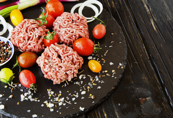 raw minced meat, vegetables with salt and spices, selective focus
