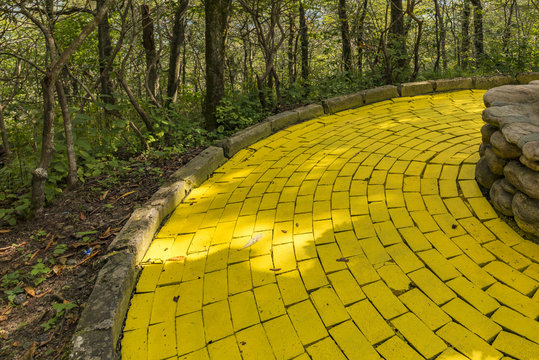 Winding yellow brick road with stone edges and a shallow depth of field