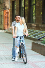Fototapeta na wymiar Happy couple with bicycle on street