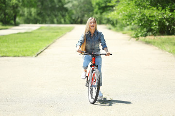 Naklejka premium Woman riding bicycle in the park