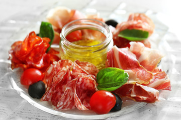 Plate with tasty meat snacks on wooden table
