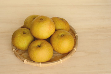 ザルに入った梨　木目背景

