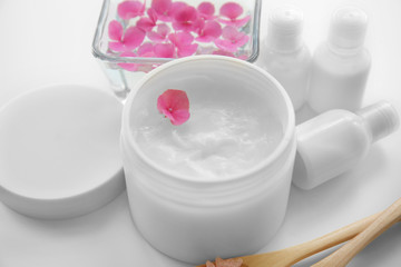 Composition with cosmetic cream and flower petals closeup